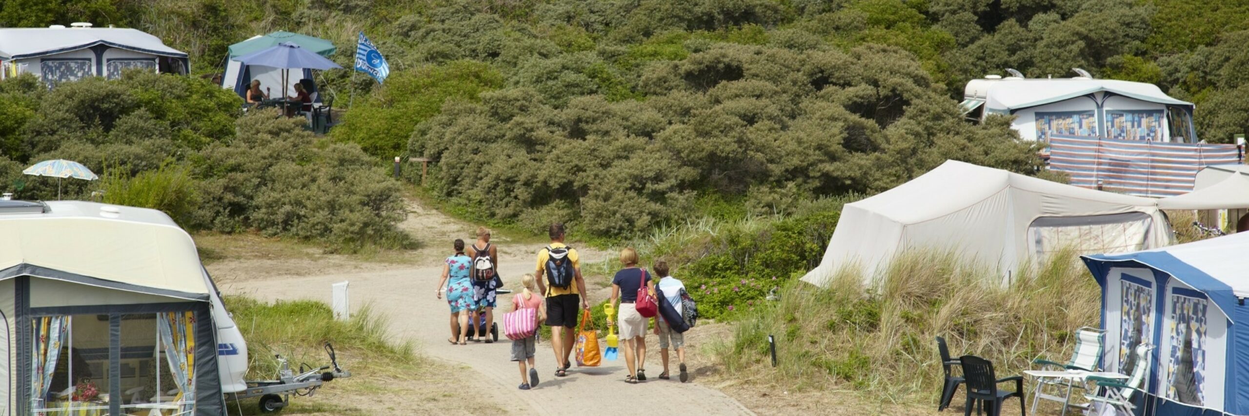 Groep loopt richting strand op Camping Kogerstrand VVV Texel